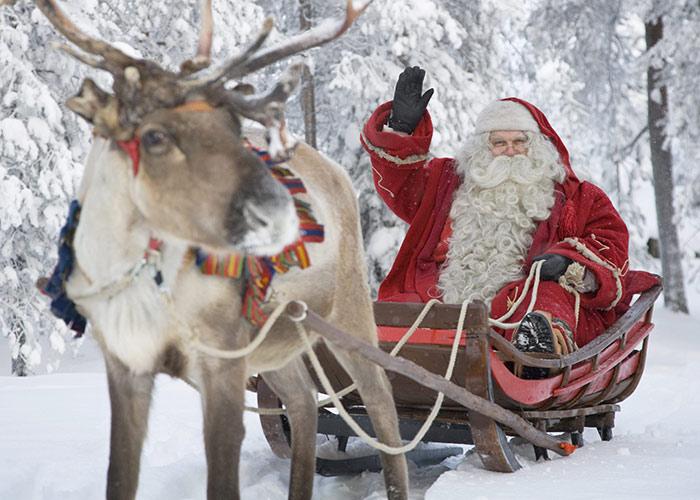 santa on sleigh with reindeer in snow