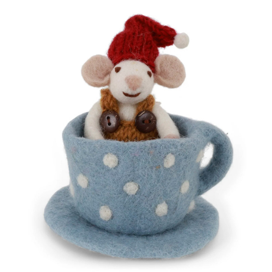A small plush mouse wearing a red Santa hat and brown scarf, sitting inside a light blue felt teacup with white polka dots and a matching saucer, photographed on a plain white background.